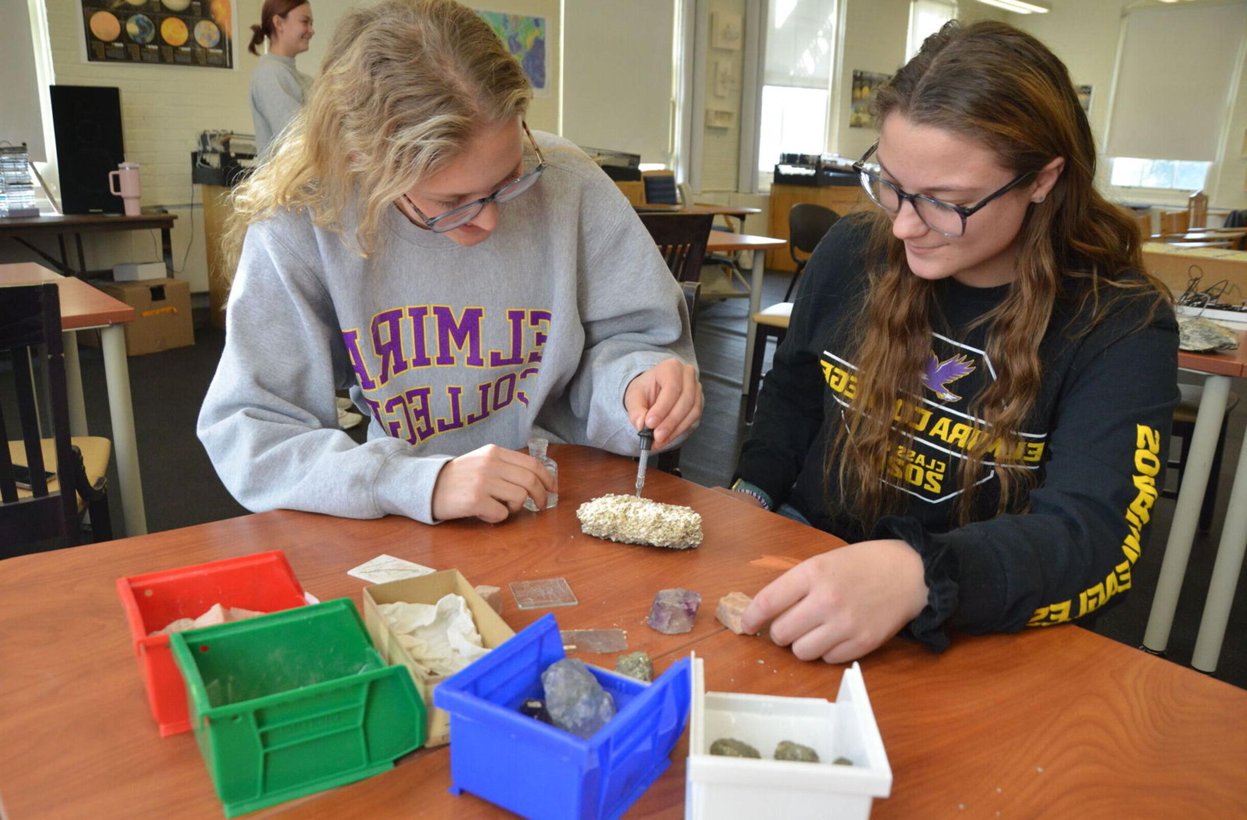 Two female students experiment with rocks in an Environmental Science class