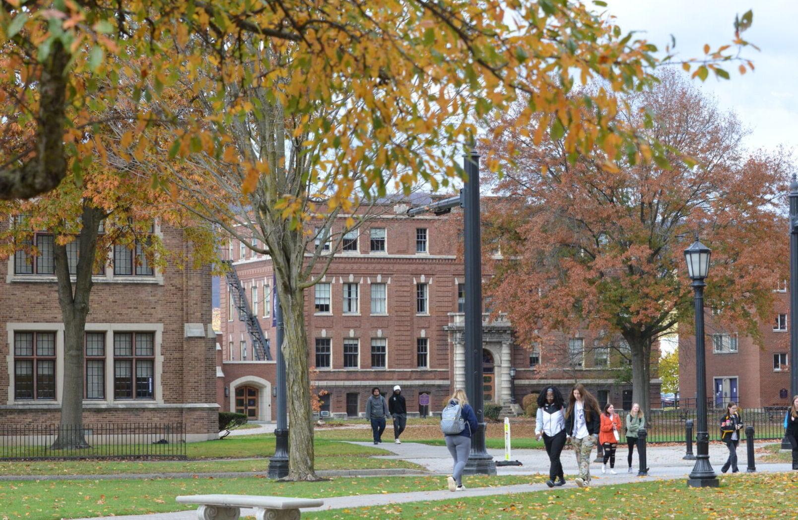 学生们走在校园周围的树木与五颜六色的秋叶