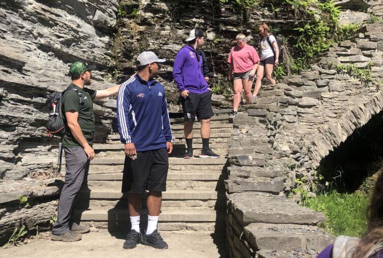 学生们在瀑布旁边的岩石楼梯上徒步